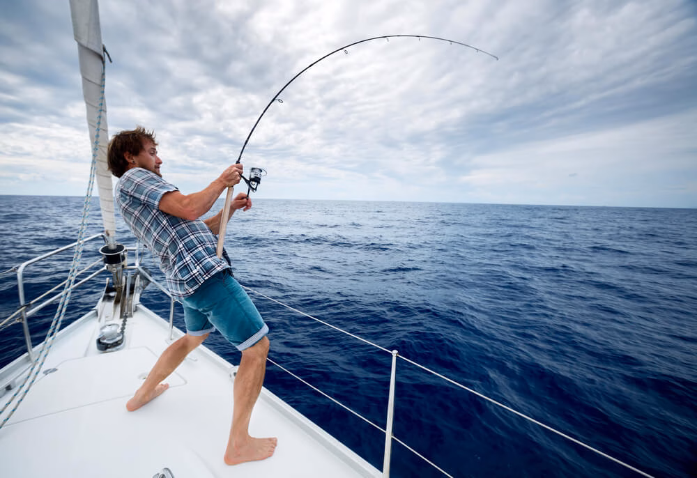 Tourist on board struggling to get fish out of water